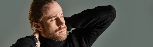Portrait of handsome man in turtleneck sweater posing with hands behind neck on grey, banner — Stock Photo