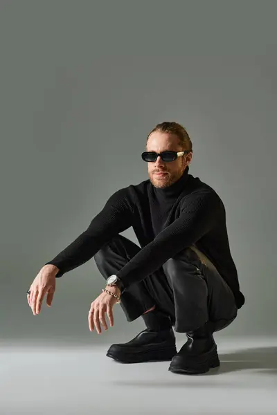 Bärtiger Mann mit trendiger Sonnenbrille, Rollkragenpullover und Lederhose auf grauen Haxen — Stockfoto