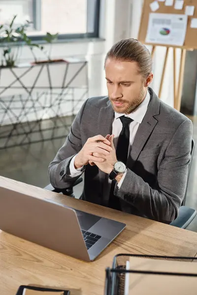 Pensive businessman in grey suit looking at notebook at workplace in office, creative thinking — Stock Photo