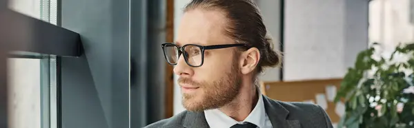 Copricapo di uomo d'affari pensieroso in abito grigio e occhiali che distoglie lo sguardo in ufficio moderno, banner — Foto stock