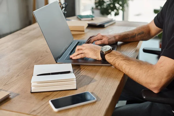 Vista recortada de hombre de negocios escribiendo en el ordenador portátil cerca de portátil y teléfono inteligente con pantalla en blanco - foto de stock