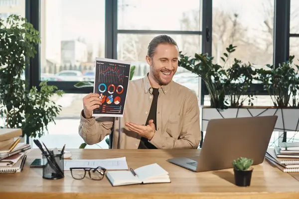 Empresário de sucesso mostrando gráficos durante videoconferência no laptop no local de trabalho no escritório — Fotografia de Stock