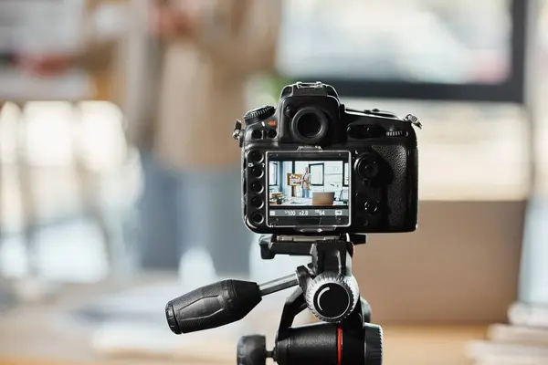 Selective focus on digital camera near blurred entrepreneur recording video blog in modern office — Stock Photo