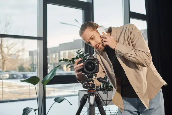 Geschäftsmann spricht auf Smartphone in der Nähe professioneller Digitalkamera im Büro, Videoblogger — Stockfoto