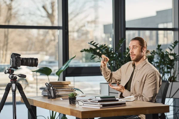 Beeindruckt Unternehmer hält Bitcoins in der Nähe Digitalkamera während Videoblog in modernem Büro — Stockfoto