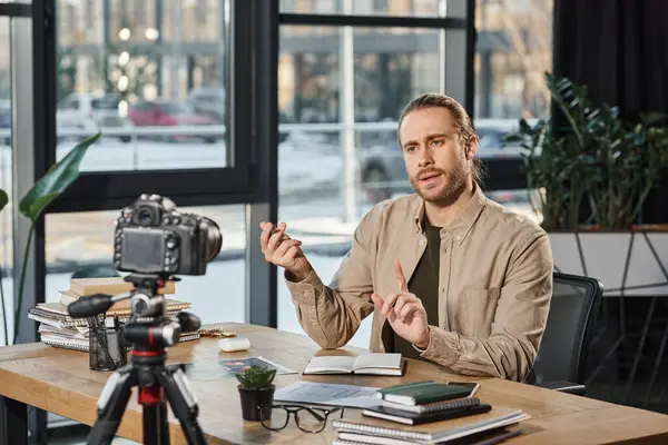 Seriöser Unternehmer spricht und gestikuliert vor Digitalkamera während Videoblog im Büro — Stockfoto