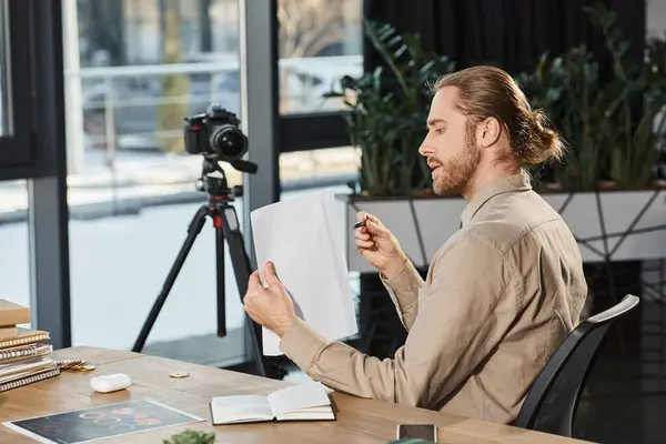 Geschäftsmann in Freizeitkleidung zeigt Dokument vor Digitalkamera und nimmt Videoblog im Büro auf — Stockfoto