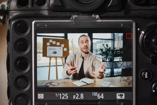 Vue rapprochée de la caméra numérique près du gestionnaire d'entreprise enregistrant du contenu vidéo dans un bureau moderne — Photo de stock