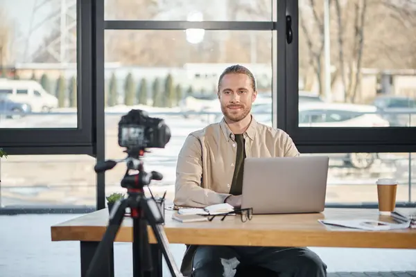 Empresário de sucesso sentado na mesa de trabalho na frente da câmera digital durante vídeo blog no escritório — Fotografia de Stock