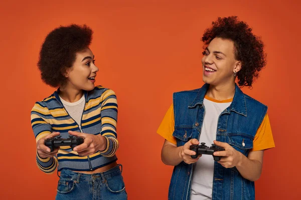 Привлекательный африканский американский брат и сестра, играющие в видеоигры с джойстиками, семейная концепция — стоковое фото