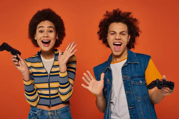 Irmãos afro-americanos bonitos em trajes casuais jogando videogames, conceito de família — Fotografia de Stock