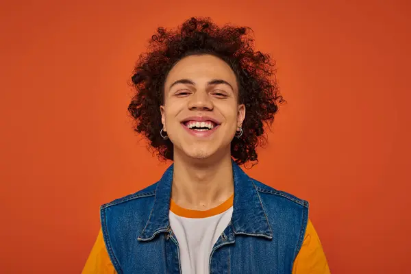 Handsome stylish african american man in casual urban attire posing emotionally on orange background — Stock Photo