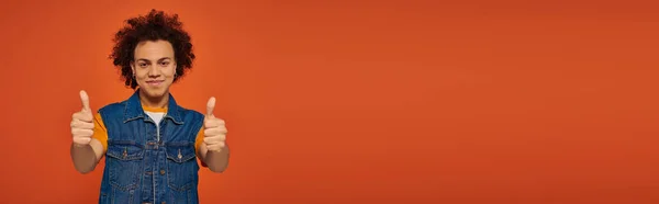 Привлекательный африканский американец в повседневной городской одежде эмоционально позирует на оранжевом фоне, баннер — стоковое фото
