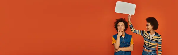 Junge afrikanisch-amerikanische Schwester und Bruder posieren mit Sprechblase auf orangefarbenem Hintergrund, Banner — Stockfoto