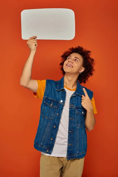 Jolly african american male model in casual attire posing with speech bubble on orange backdrop — Stock Photo
