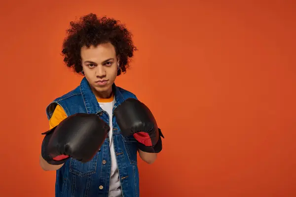 Bell'aspetto sportivo afro-americano uomo in posa vivace in guanti da boxe su sfondo arancione — Foto stock