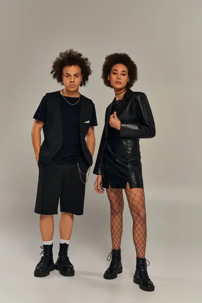Attrayants frères et sœurs afro-américains à la mode dans des tenues noires élégantes posant activement ensemble — Photo de stock