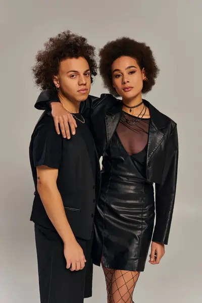 Gut aussehende afrikanisch-amerikanische Geschwister in urbaner stylischer Kleidung umarmen sich herzlich auf grauem Hintergrund — Stockfoto