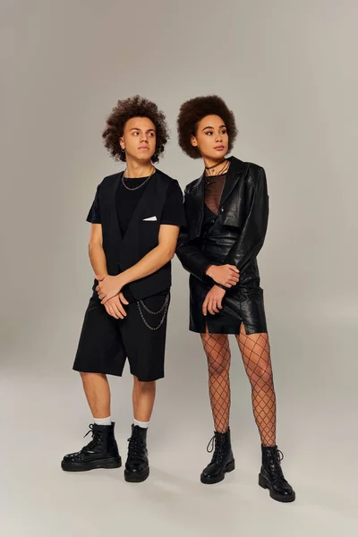 Attraktiv stylische afrikanisch-amerikanische Geschwister in modischen schwarzen Outfits posieren aktiv zusammen — Stockfoto