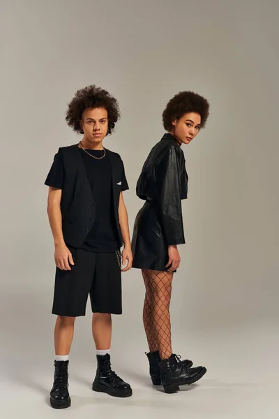 Attractive stylish african american siblings in fashionable black outfits posing actively together — Stock Photo