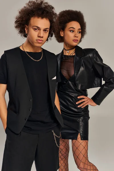 Attrayants frères et sœurs afro-américains élégants dans des tenues noires à la mode posant animés ensemble — Photo de stock