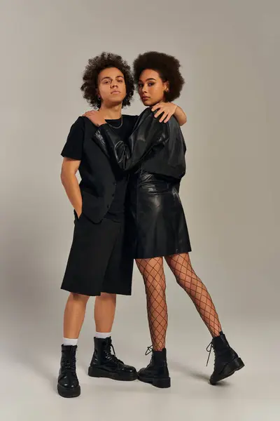 Gut aussehende trendige afrikanisch-amerikanische Geschwister in schwarzen Outfits, die sich herzlich umarmen, Familienkonzept — Stockfoto
