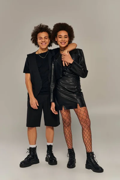 Joyeux frère et sœur afro-américaine élégant dans des tenues à la mode étreignant et souriant joyeusement — Photo de stock