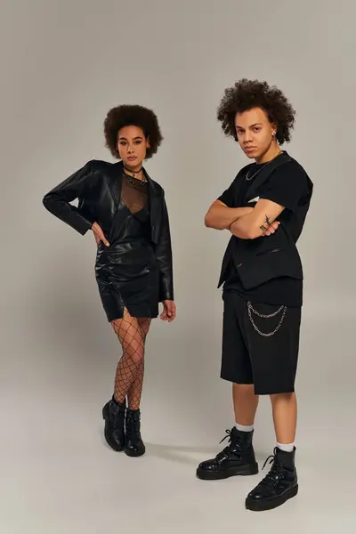 Jeunes frères et sœurs afro-américains à la mode en tenue urbaine élégante posant ensemble sur fond gris — Photo de stock