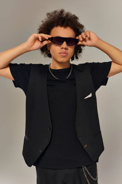 Guapo afroamericano de moda en traje de moda con gafas de sol elegantes posando en la cámara - foto de stock