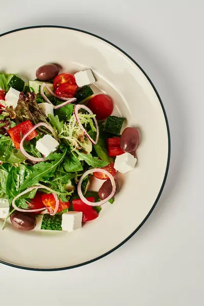 Vertikales Foto des Tellers mit frisch zubereitetem köstlichen griechischen Salat auf grauem Hintergrund, gesunde Ernährung — Stockfoto