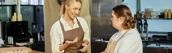 Administrador alegre hablando con una joven empleada con síndrome de Down en la cafetería moderna, pancarta - foto de stock