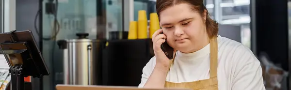 Jeune femme avec un handicap mental parler sur smartphone tout en travaillant dans un café moderne, bannière — Photo de stock