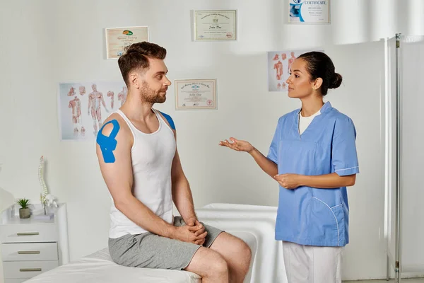 Good looking bearded patient and attractive young doctor looking at each other attentively — Stock Photo