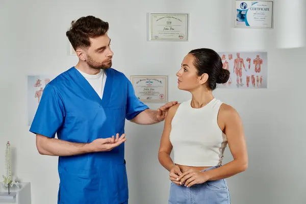 Hermosa mujer joven mirando a su guapo médico con barba durante la cita, atención médica - foto de stock