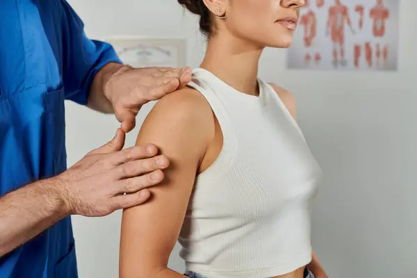 Vista ritagliata del medico che controlla i muscoli della sua giovane paziente durante l'appuntamento, assistenza sanitaria — Foto stock