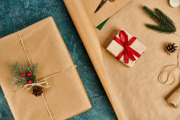 Present boxes and pine decor with twine on wrapping paper on blue textured backdrop, feast theme — Stock Photo