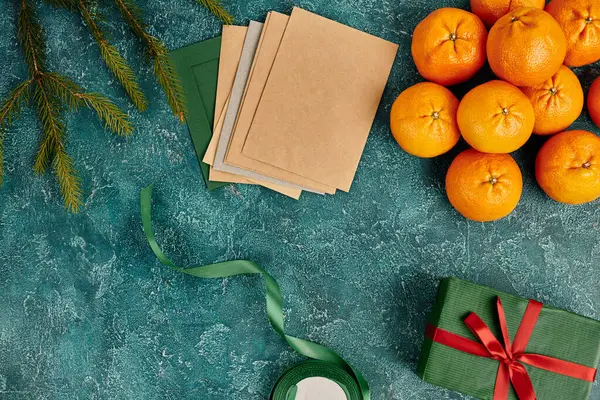 Lettres de vœux et mandarines près des branches de pin et ruban décor sur fond texturé bleu — Photo de stock
