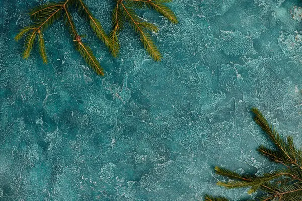 Draufsicht auf grüne Kiefernzweige auf blau strukturiertem Hintergrund mit Leerraum, Weihnachtshintergrund — Stockfoto