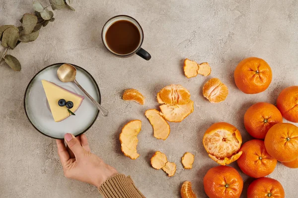Cropped view of woman near pudding, tangerines and hot chocolate drink, traditional Christmas treats — Stock Photo