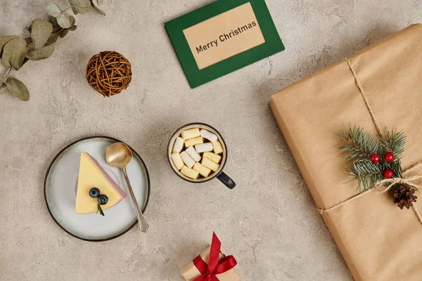Dulces tradicionales de Navidad, pudín y chocolate caliente con malvaviscos cerca de la caja de regalo decorada - foto de stock