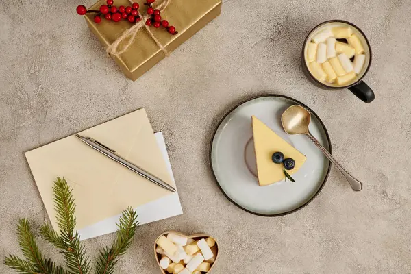 Christmas pudding and hot chocolate with marshmallows near envelopes and pen on textured backdrop — Stock Photo