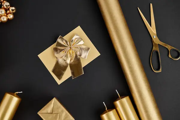 Oggetti natalizi dorati su sfondo nero, forbici vicino carta arrotolata e candele, artigianato natalizio — Foto stock