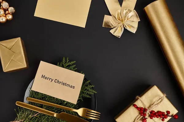 Greeting card with Merry Christmas lettering near golden cutlery and shiny Christmas decor on black — Stock Photo