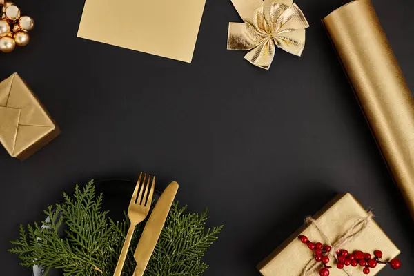 Couverts dorés sur branches de genièvre près décor de Noël brillant sur fond noir, cadre festif — Photo de stock