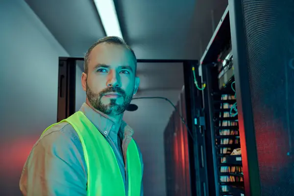 Good looking specialist with beard in safety clothes inspecting data center and looking away — Stock Photo