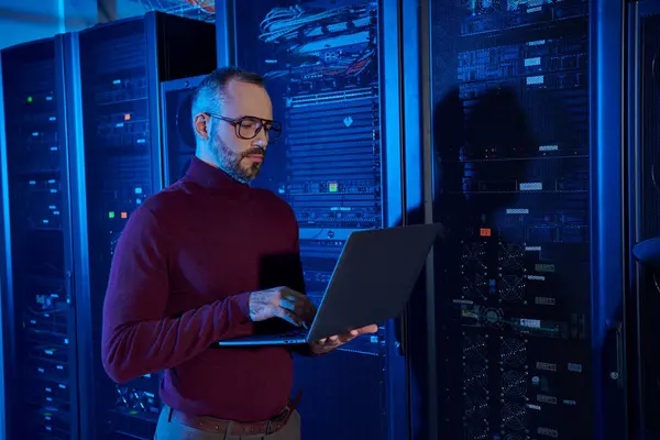 Good looking concentrated specialist in turtleneck with beard working on his laptop attentively — Stock Photo