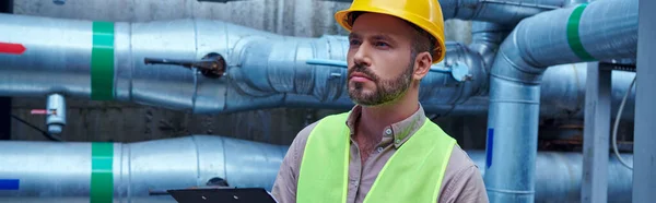 Pensive technician in safety vest and yellow helmet outside of data center looking away, banner — Stock Photo