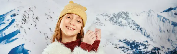 Vorpubertierendes süßes Mädchen mit Schnee in den Händen, fröhlich lächelnd in die Kamera, Mode und Stil, Banner — Stockfoto
