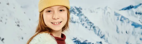 Модная маленькая девочка в теплом стильном наряде улыбается на камеру с горным фоном, модой, баннером — стоковое фото
