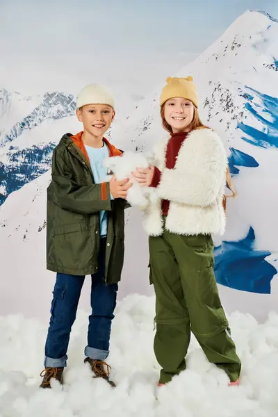 Vertical shot of happy preadolescent friends in warm outfits posing with snow in hands, fashion — Stock Photo